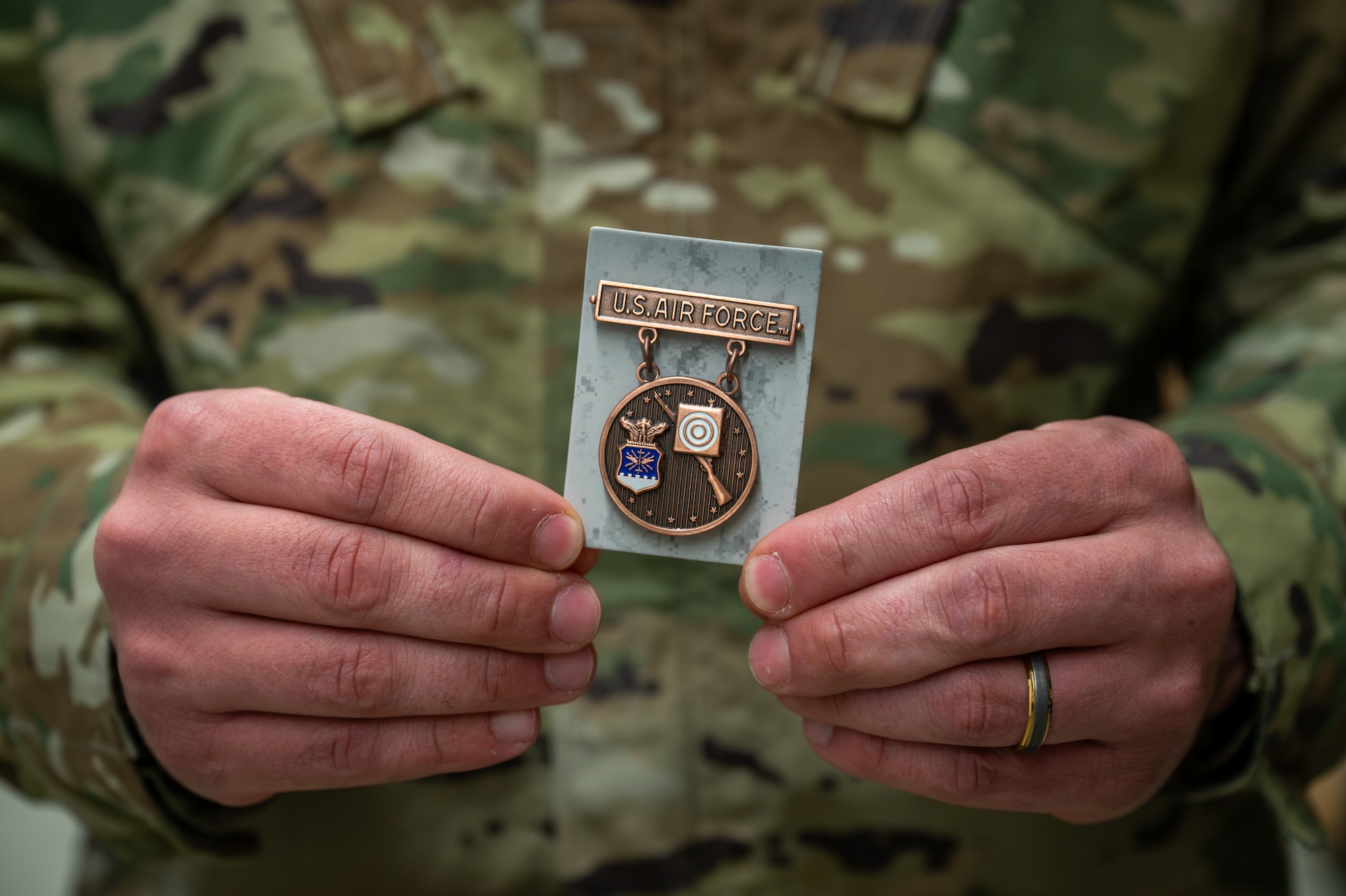 U.S. Air Force service member holds an U.S. Air Force Excellence-in-Competition Rifleman Badge.