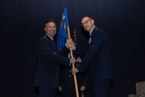 Lt. Col. Nicholas Brence accepts guidon from AFIMSC commander, Maj. Gen. Thomas Sherman.