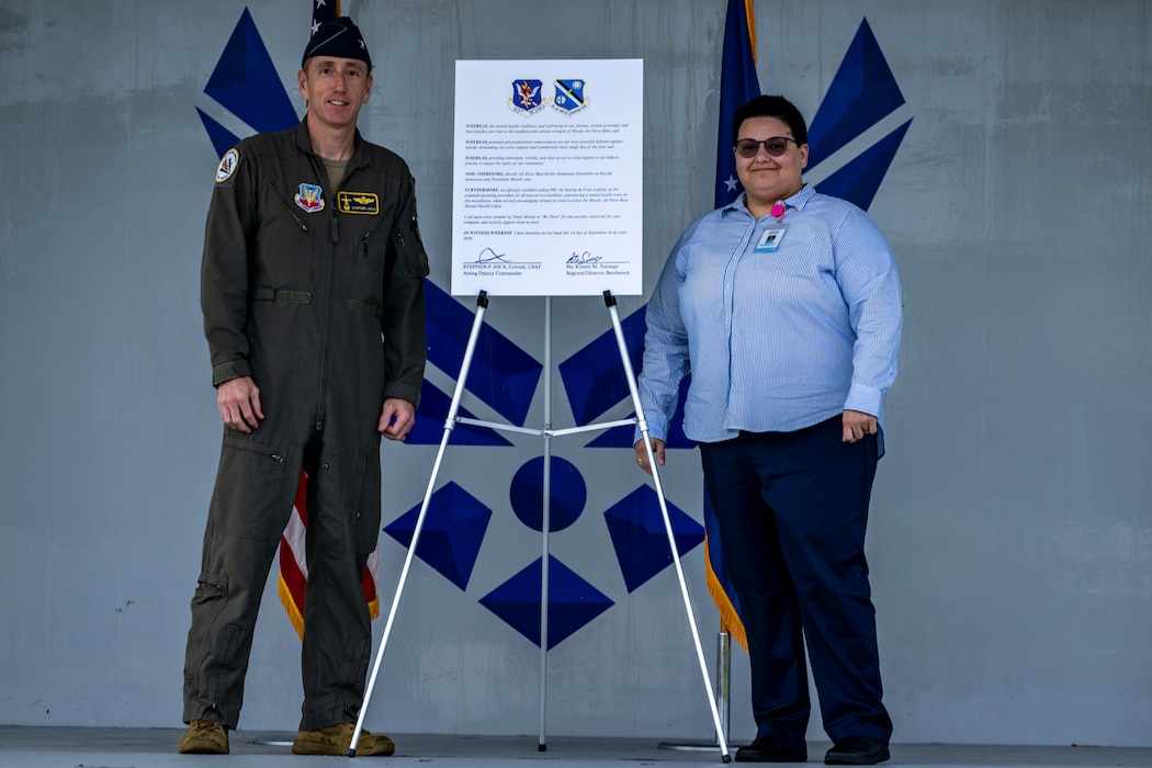 U.S. Air Force Colonel and speaker pose next to proclamation