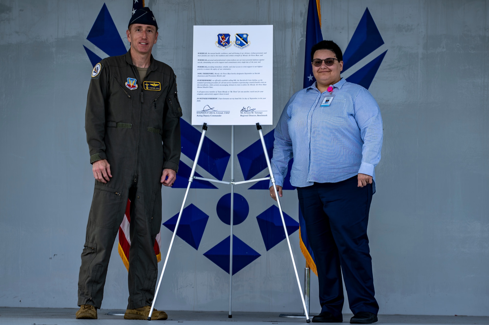U.S. Air Force Colonel and speaker pose next to proclamation