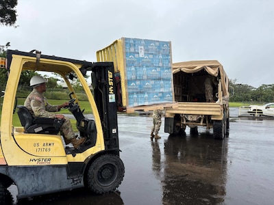 Sgt. First Class Keith Reiswig, readiness noncommissioned officer, Company B, 227th Brigade Engineer Battalion, Hawaii National Guard, assists with loading water.