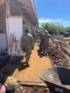 Task Force Hawaii Soldiers work in Naalehu to clear debris left behind by Tropical Storm Lala.