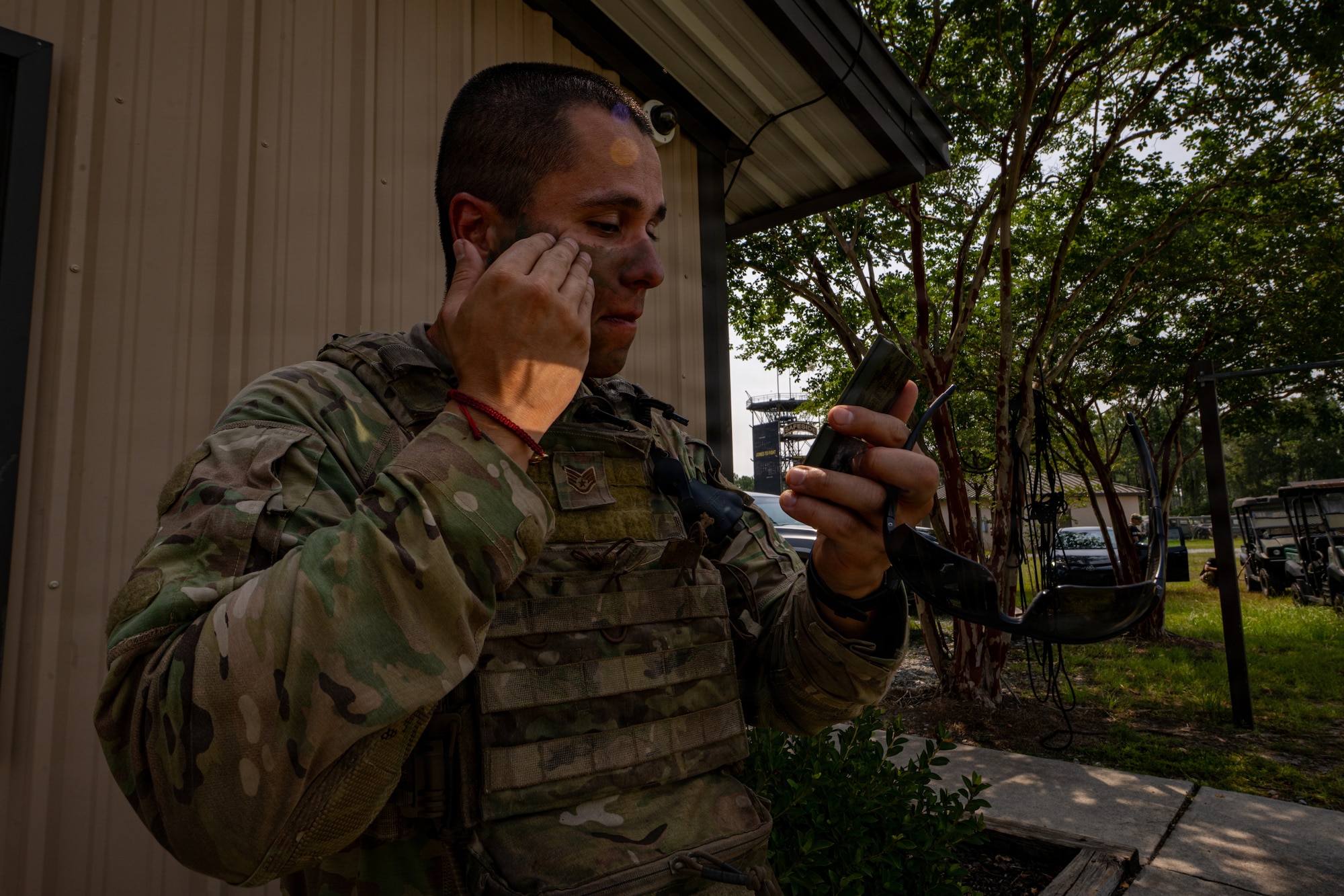 Airman putting on camouflage.