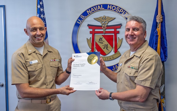 YOKOSUKA, Japan (Sept. 1, 2026) — Capt. Raj Singaraju, chief medical officer at U.S. Naval Hospital Yokosuka, and Capt. Joshua A. Miller, director of U.S. Naval Hospital Yokosuka and commanding officer of U.S. Navy Medicine Readiness and Training Command Yokosuka, pose with the Joint Commission accreditation certificate. The Joint Commission accredited the hospital for all services surveyed. (U.S. Navy photo by Daniel Taylor, USNMRTC Yokosuka Public Affairs)