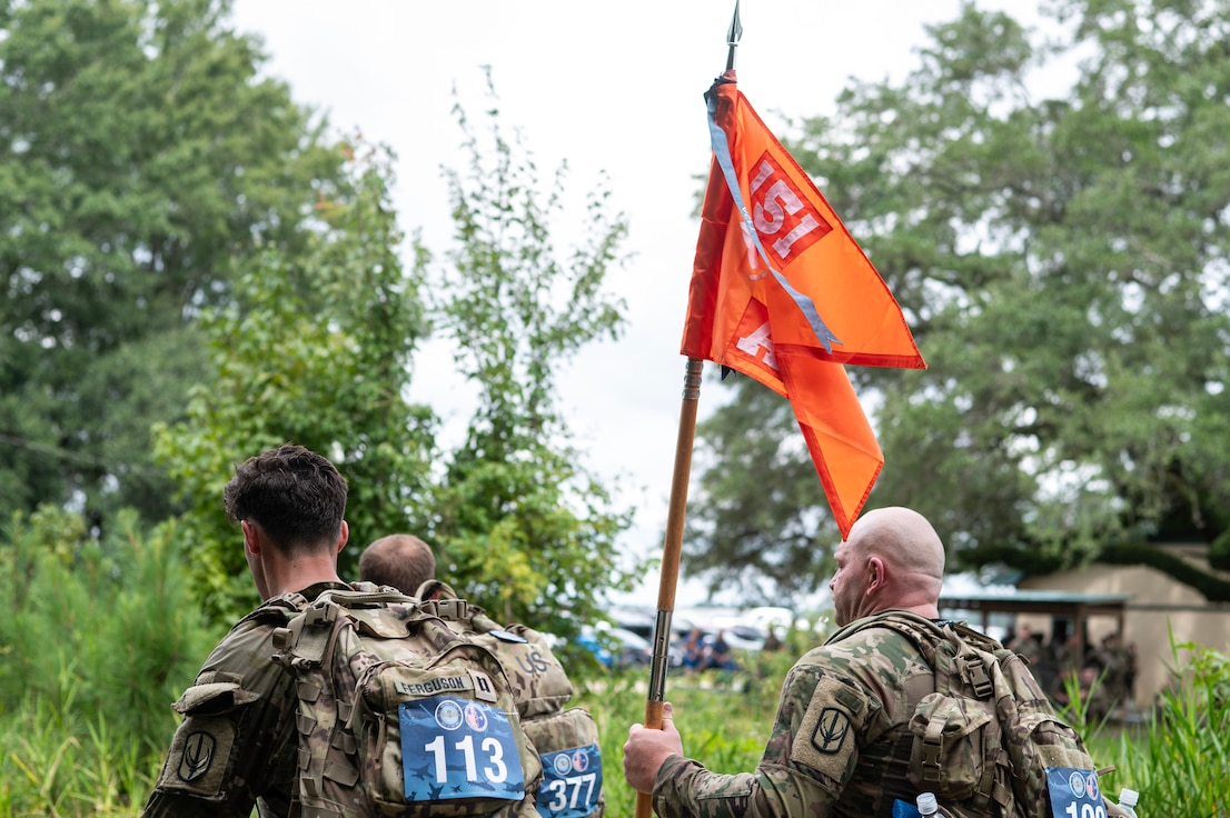 soldiers rucking with guidon