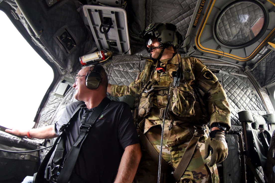 civilian flying in helicopter with crew chief