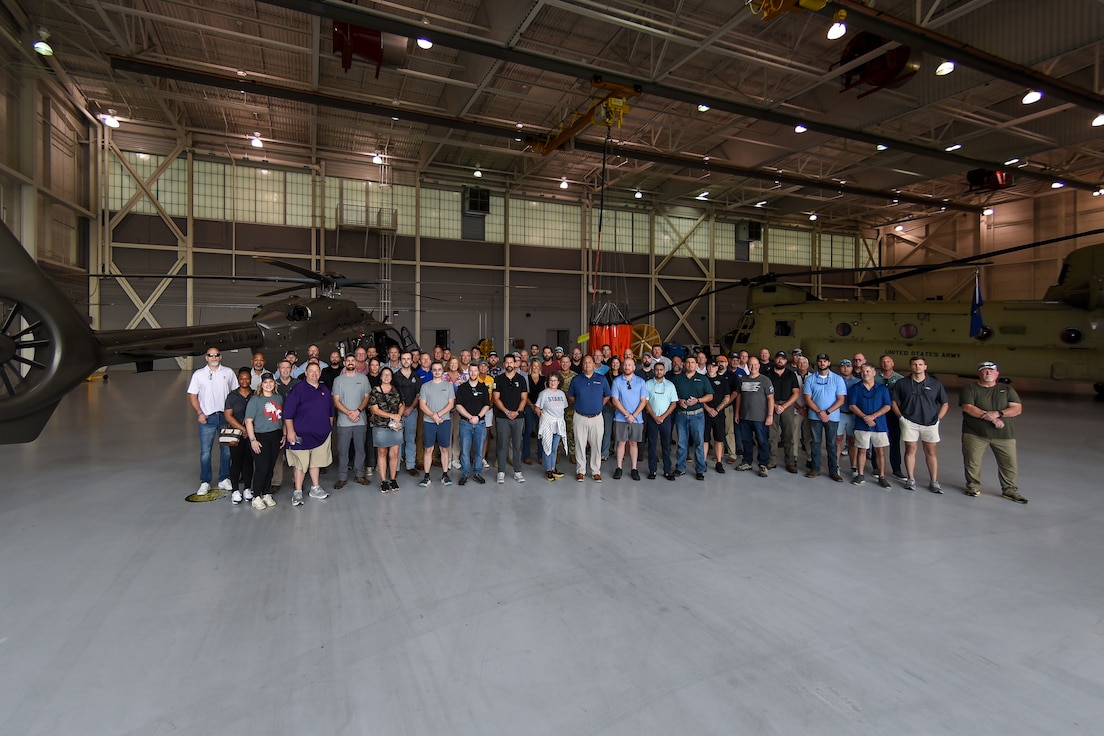group photo in front of helicopter