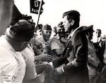 The late President John F. Kennedy taking with AFROTC cadets, members of D Flight, first period Summer Training Unit 1962 at Otis AFB, Mass Tactical Officer of D Flight, Captain Healy, is in the background. (Courtesy Photo)