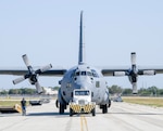 A ground crew tows a U.S. Air Force C-130H Hercules to a parking spot at Kelly Field, Joint Base San Antonio-Lackland, Texas, Aug. 24, 2026. This aircraft is scheduled to be retired and serve as a dedicated training platform for Basic Military Training NEXT, giving trainees a more realistic view of the airfield environment and the operational Air Force. (U.S. Air Force photo by Kristian Carter)