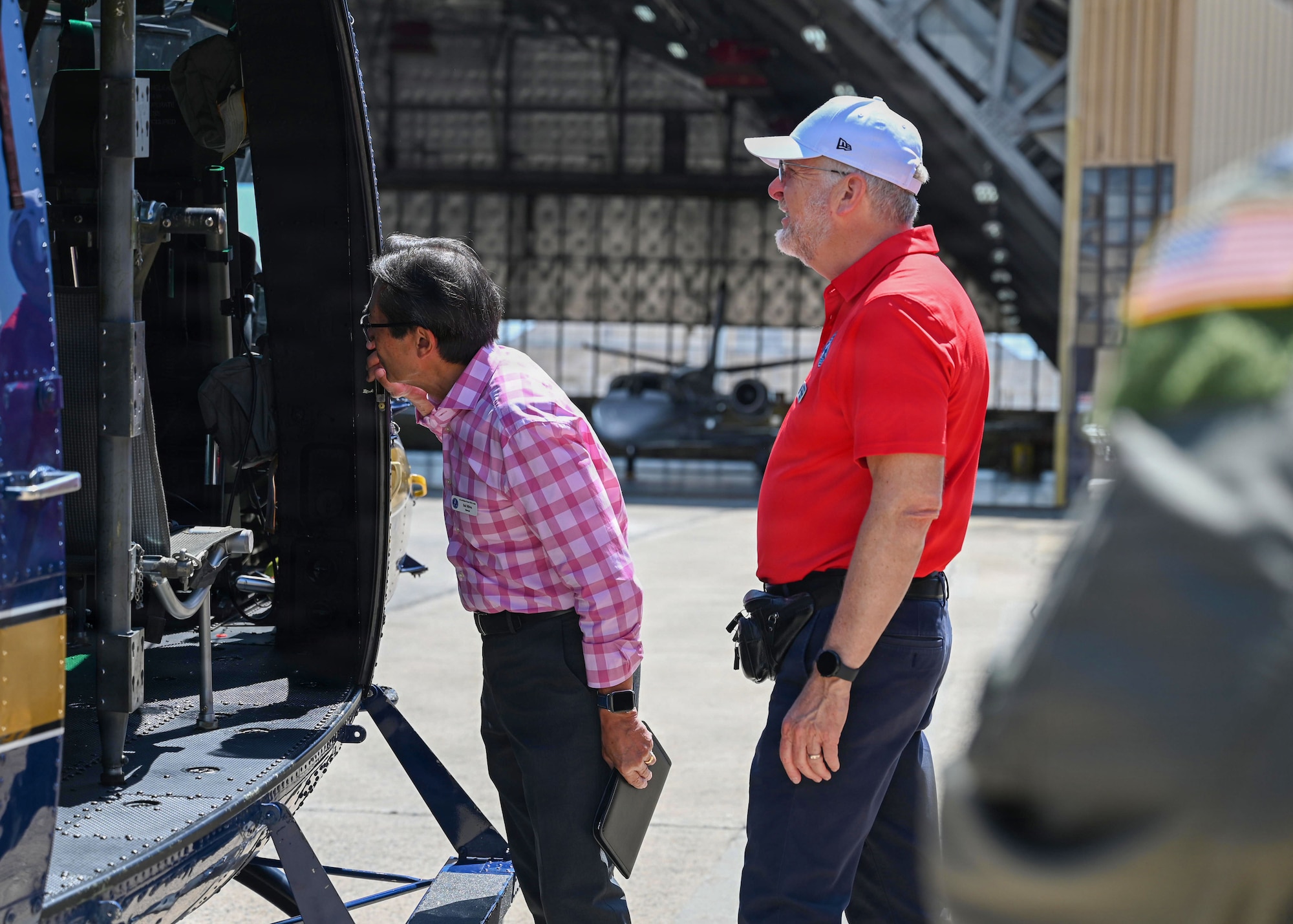 Two men looking inside a helicopter.