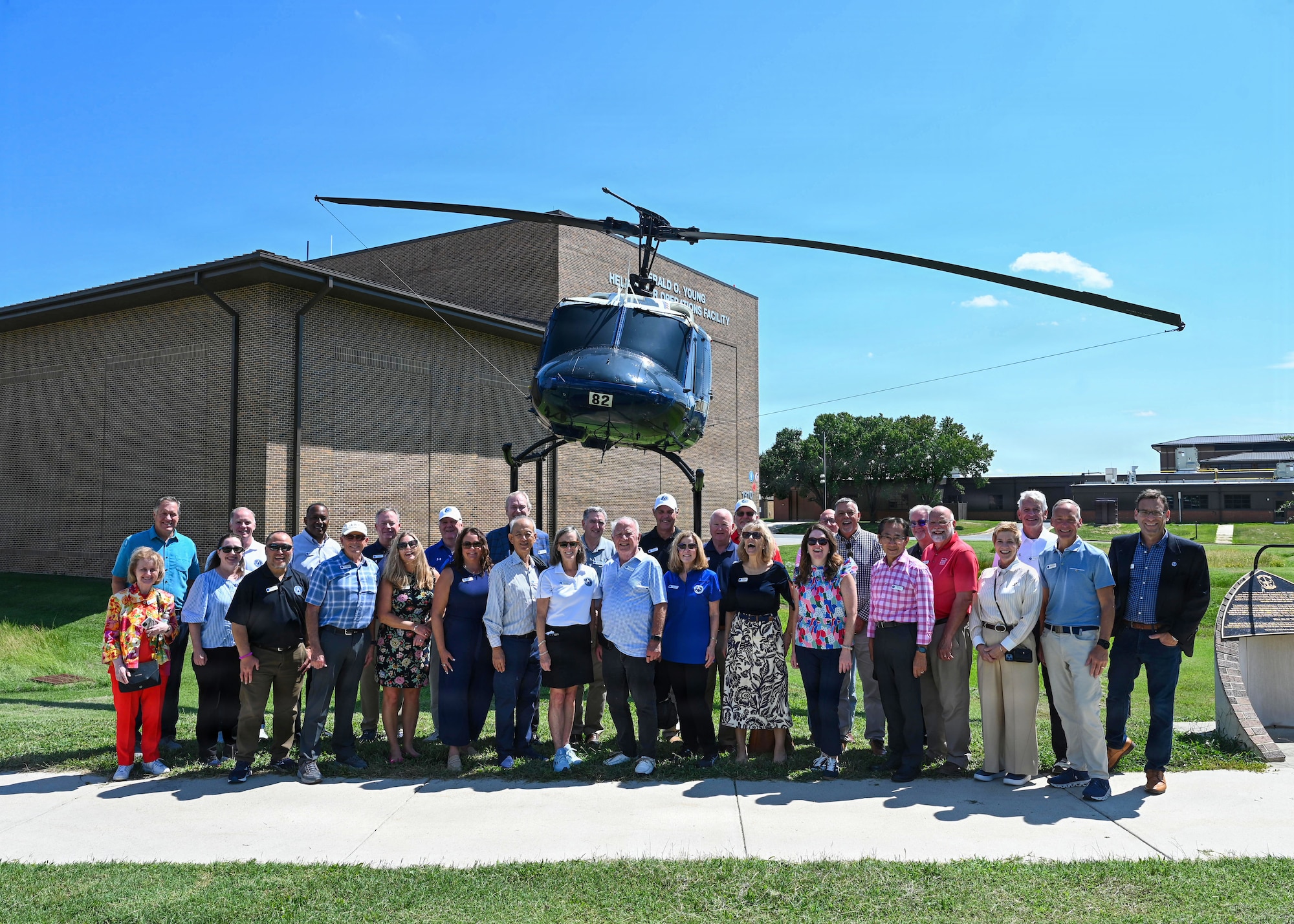 A group of people standing in front of a parked helicopter.