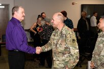 Kevin Culihan shakes hands with Command Sgt. Maj. Andrew DeCola following Culihan’s retirement ceremony Aug. 31 at Fort Detrick, Maryland.