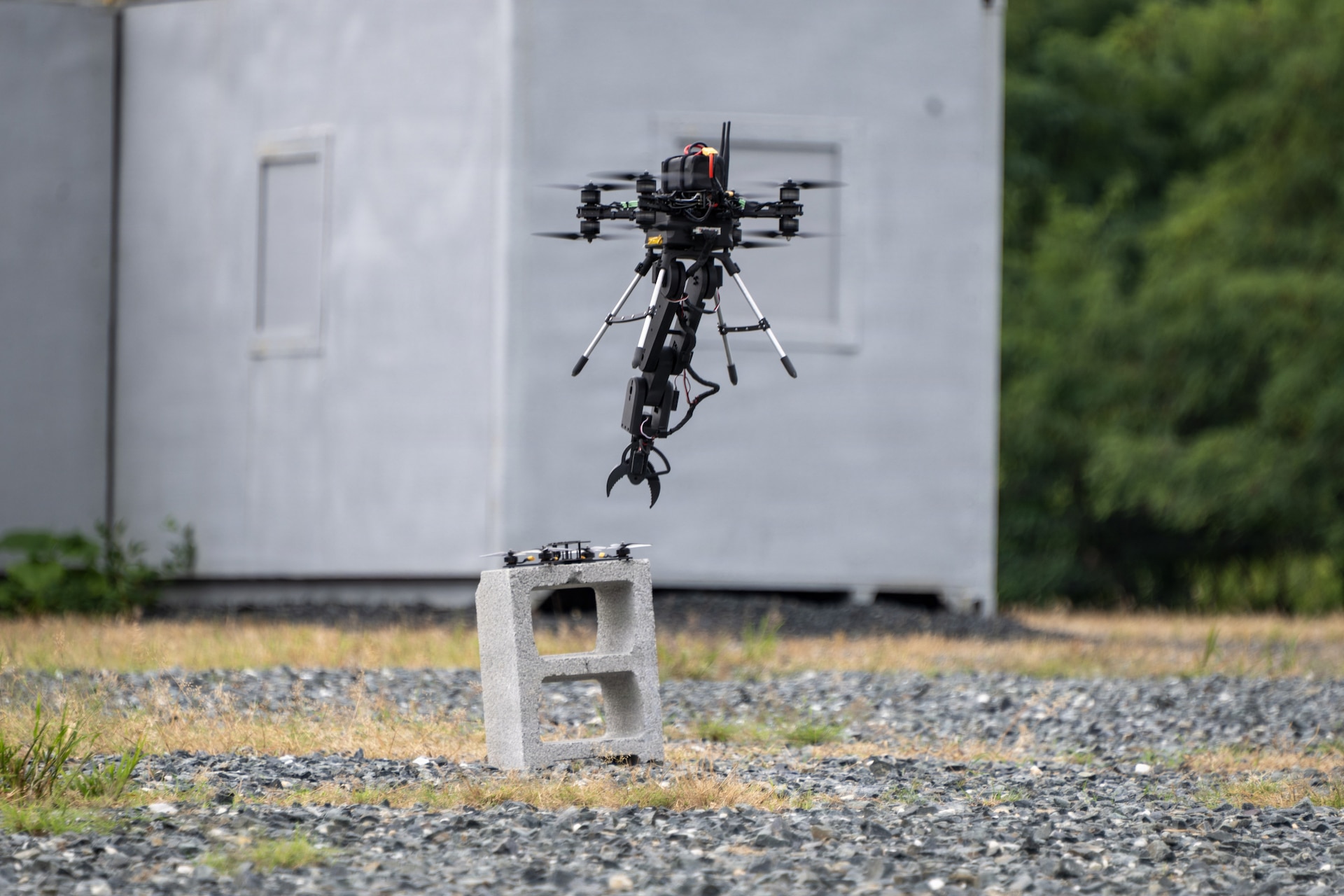 The Pennsylvania National Guard Unmanned Aircraft System Training and Innovation Facility's Project R.E.D. drone, with its mechanical arm extended, prepares to pick up another drone during U.S. Army Combat Capabilities Development Command’s Robotics and Autonomy Showcase Aug. 27, 2026, at Aberdeen Proving Ground, Maryland. (U.S. Army photo by Greg Newswanger)