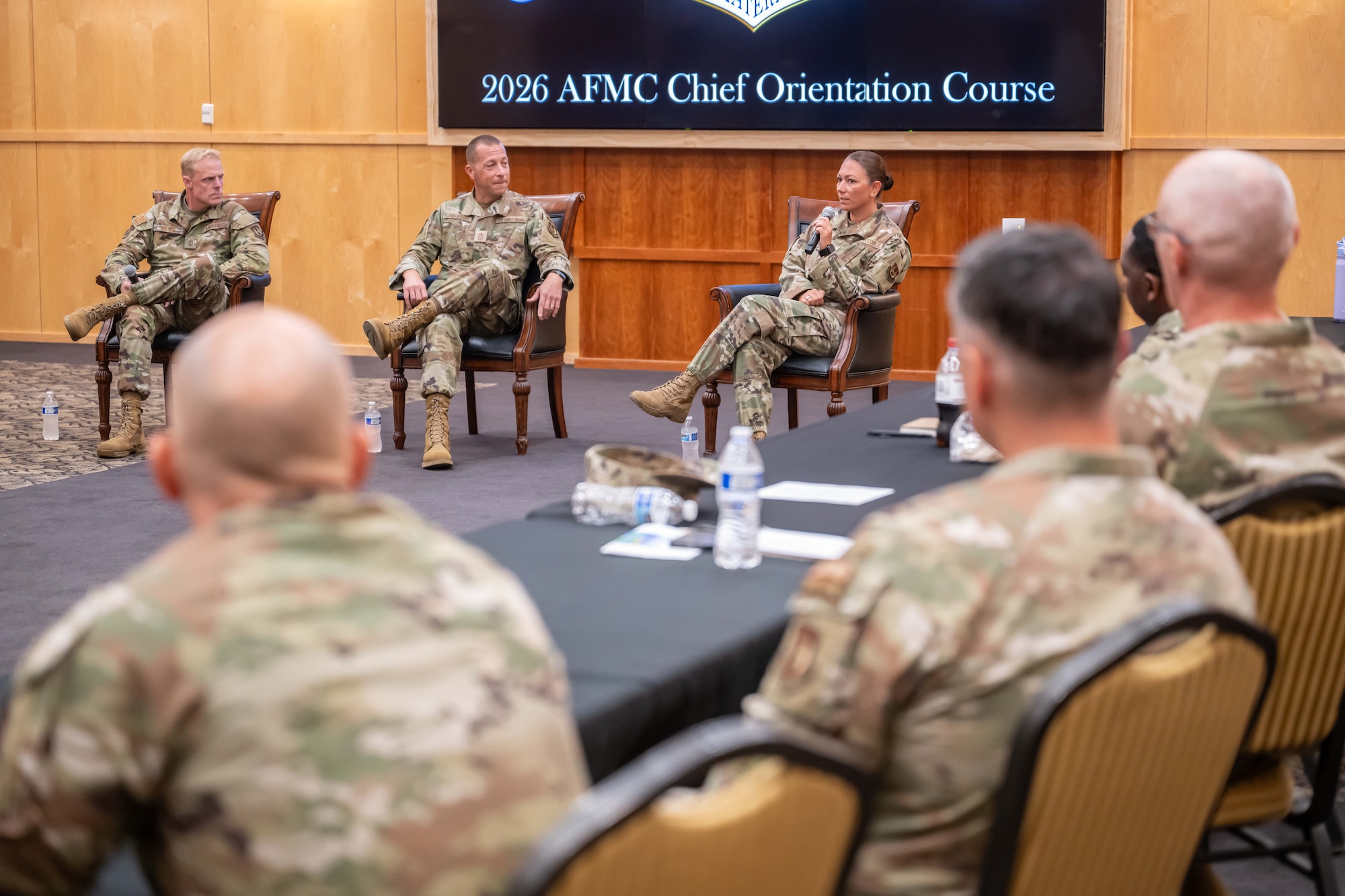 (Left to right) Chief Master Sgt. Timothy J. Wieser, Air Force Life Cycle Management Center command chief, Chief Master Sgt. Carlos Labrador, Air Force Sustainment Center command chief, and Chief Master Sgt. Sevin Balkuvvar, Air Force Test Center command chief, sitting in chairs in front of other senior enlisted leadership.