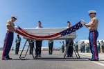 U.S. Marine Corps Staff Sgt. Seth Garner, 1st Explosive Ordnance Disposal Company eod technician (right), and U.S. Marine Corps Sgt. Isaac Jacuinde, Defense POW/MIA Accounting Agency field radio operator (left), unfurl the United States flag