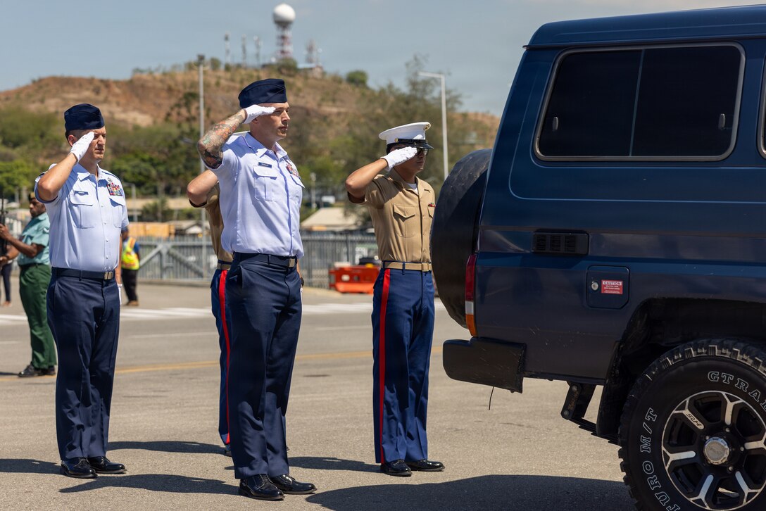 U.S. service members assigned to the Defense POW/MIA Accounting Agency render a salute.