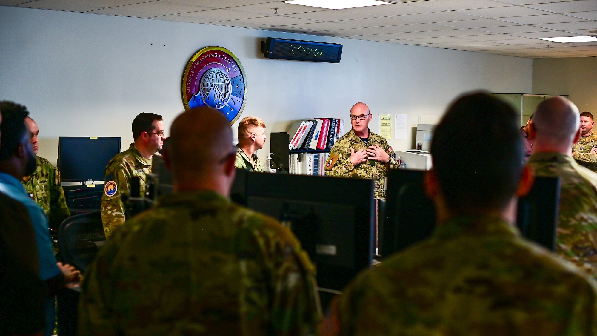 Maj. Gen. Kyle C. Paul briefs ally, joint-service and civilian personnel on the Missile Warning Center operations floor.