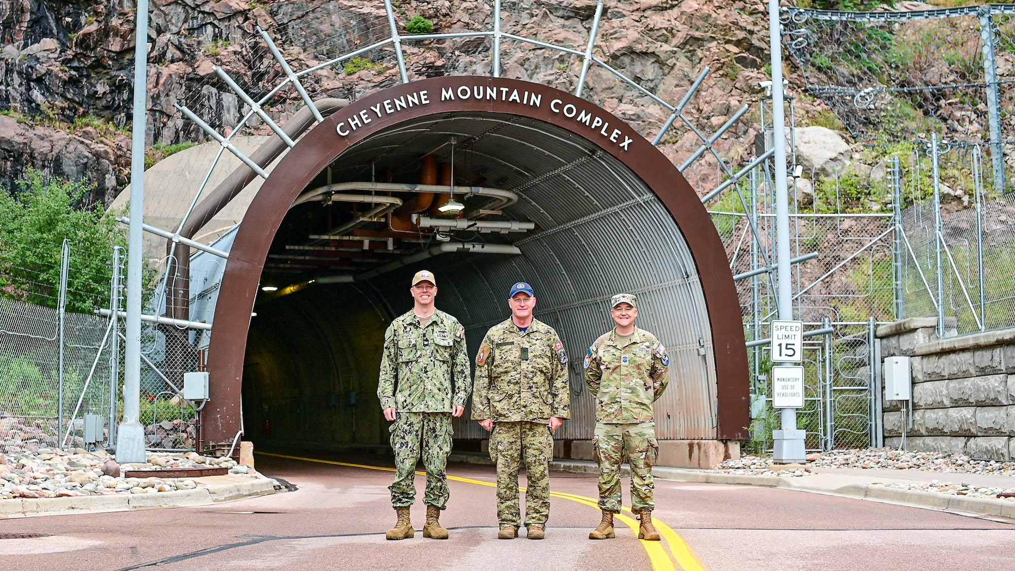 Capt. Gregory Arnold, left, Maj. Gen. Kyle C. Paul, center, and Senior Master Sgt. Matthew Myers, right, pose for a group photo at the entrance to the Cheyenne Mountain Complex at Cheyenne Mountain Space Force Station.