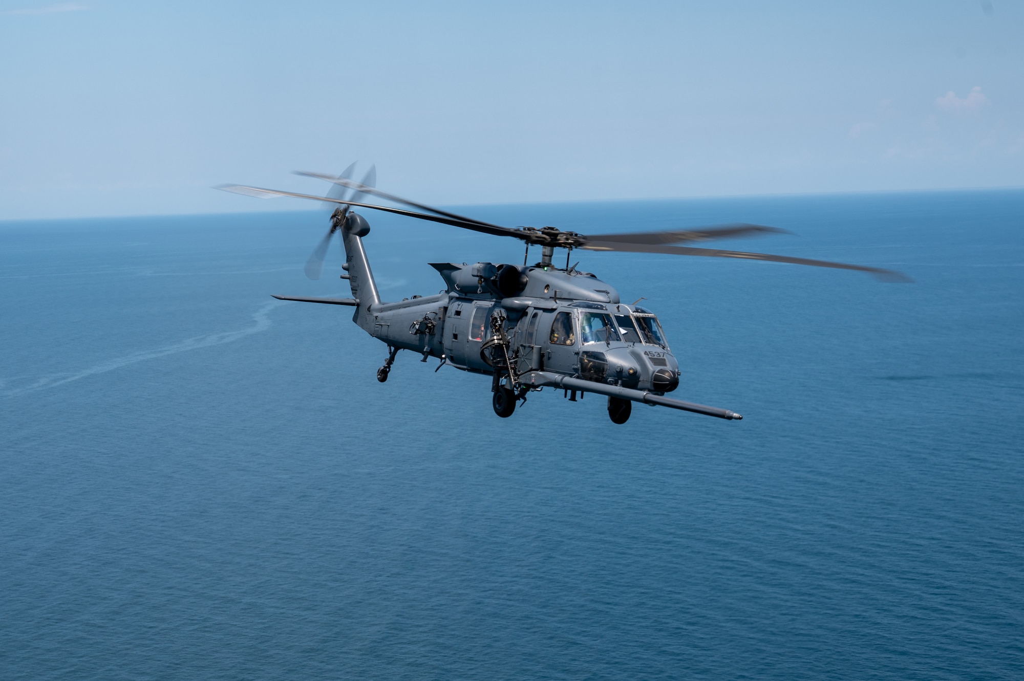 Helicopter flies over the sea.