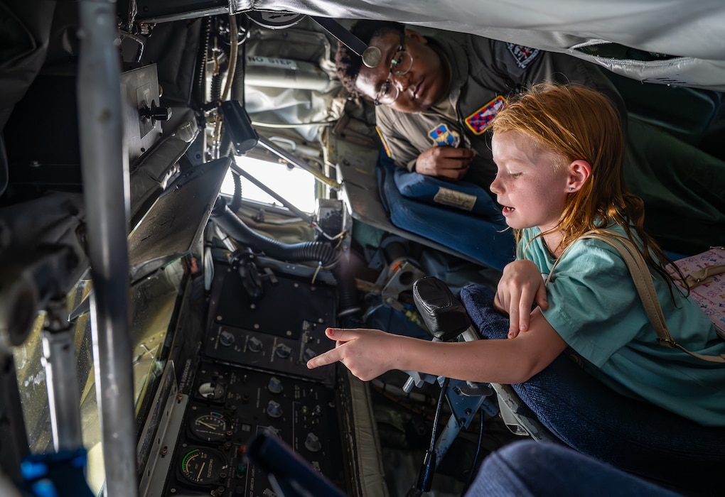 A child asks U.S. Air Force Staff Sgt. Christopher Moody, 54th Air Refueling Squadron formal training unit instructor boom operator, a question while exploring the boom pod of a U.S. Air Force KC-135 Stratotanker aircraft at Altus Air Force Base, Oklahoma, Aug. 31, 2026. For seven decades, the KC-135 has been the backbone of global reach. (U.S. Air Force photo by Airman 1st Class Emma Wright)