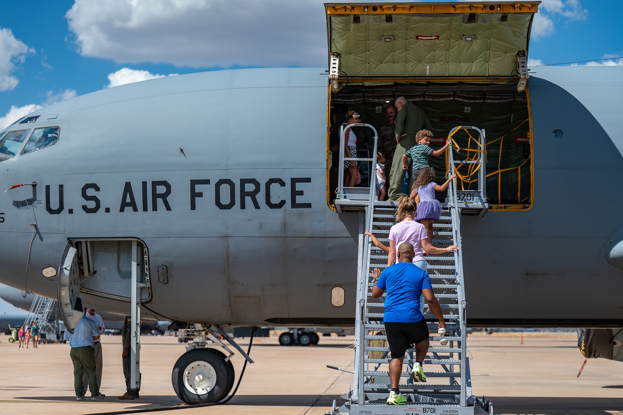 U.S. Air Force Maj. Barry James, 54th Air Refueling Squadron formal training unit instructor pilot, and his family walk in front of a U.S. Air Force KC-135 Stratotanker during the aircraft's 70th anniversary at Altus Air Force Base, Oklahoma, Aug. 31, 2026. In addition to exploring static displays, Airmen and their families also had the opportunity to operate a KC-135 Simulator and Boom Operator Weapon System Trainer. (U.S. Air Force photo by Airman 1st Class Emma Wright)