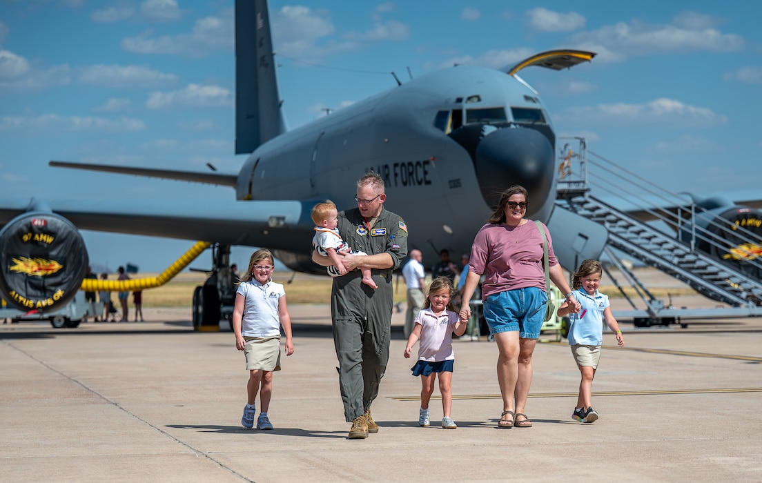 U.S. Air Force Maj. Barry James, 54th Air Refueling Squadron formal training unit instructor pilot, and his family walk in front of a U.S. Air Force KC-135 Stratotanker during the aircraft's 70th anniversary at Altus Air Force Base, Oklahoma, Aug. 31, 2026. In addition to exploring static displays, Airmen and their families also had the opportunity to operate a KC-135 Simulator and Boom Operator Weapon System Trainer. (U.S. Air Force photo by Airman 1st Class Emma Wright)