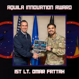 Two people stand near each other and hold an award