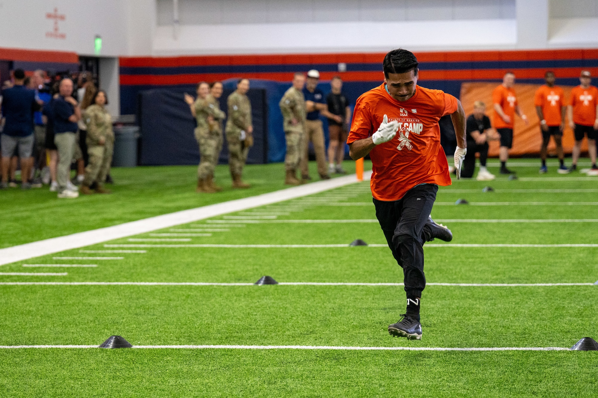 Man sprints while people stand in the background