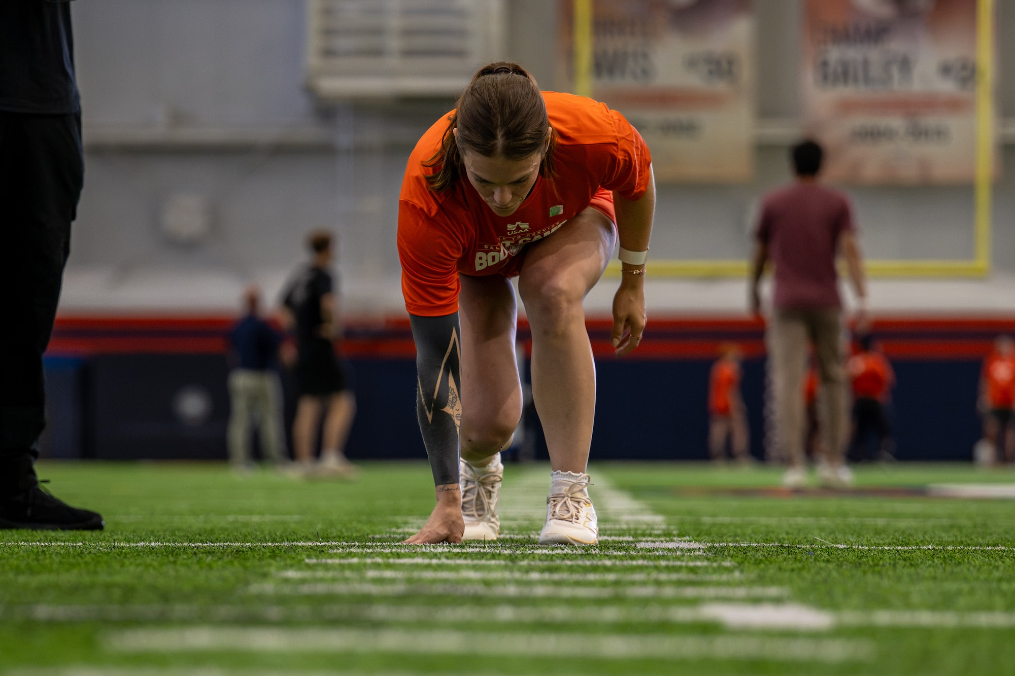 Woman prepares t sprint while people stand in the background