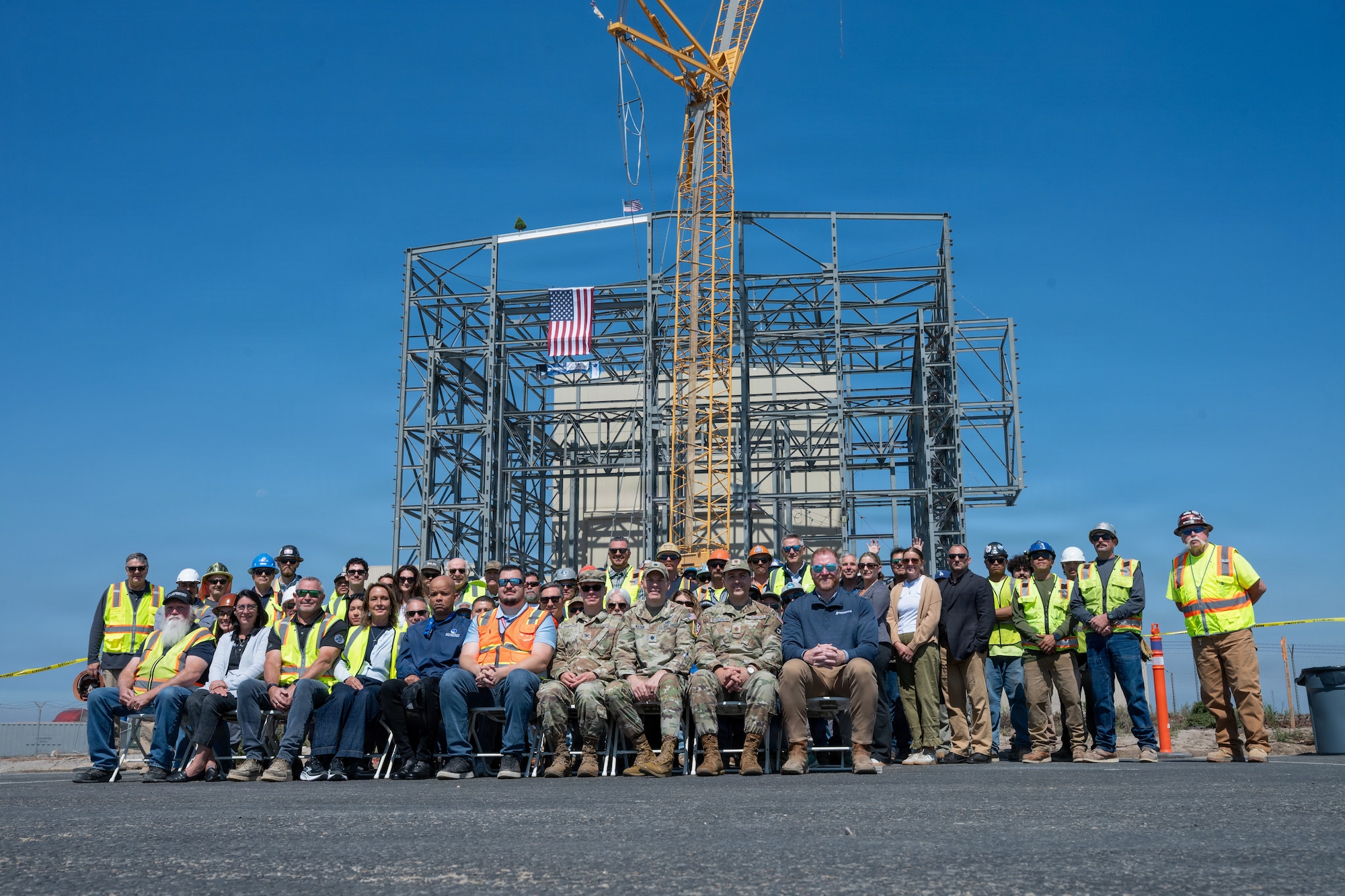 People sit in front of the construction site in a group.