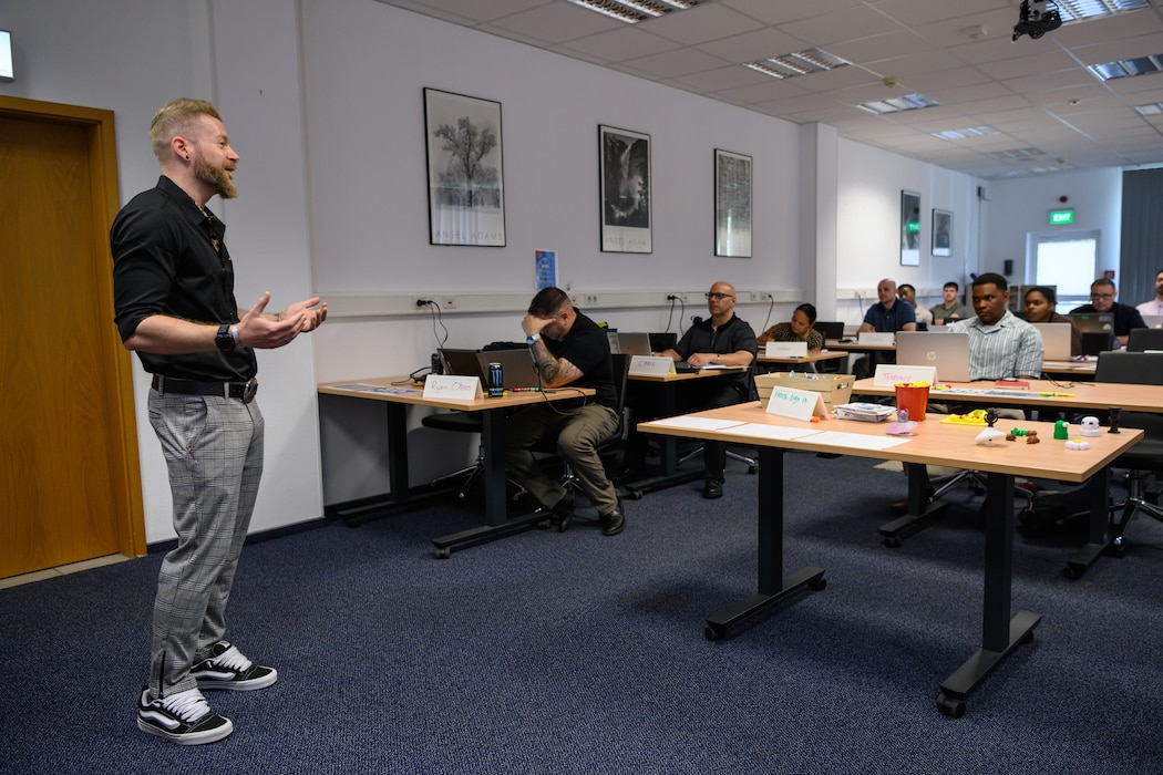A man speaks in front of a class.