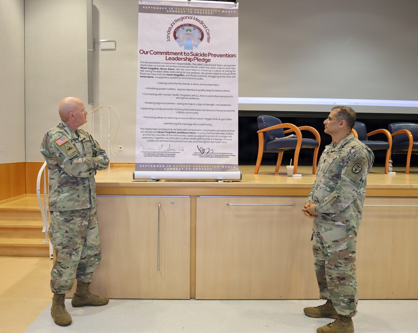 LANDSTUHL, Germany — Col Warren Stewart, commander, and Command Sgt. Maj. Jorge Oquendo, senior noncommissioned officer, Landstuhl Regional Medical Center pose after signing the Our Commitment to suicide Prevention Pledge, at the annual Suicide Prevention and Awareness month Luncheon with a dedicated observance sept 1 in the Heaton Auditorium. The ceremony opened with a video showing real text and a video of the command team talking about importance of suicide awareness and a fireside chat with providers.