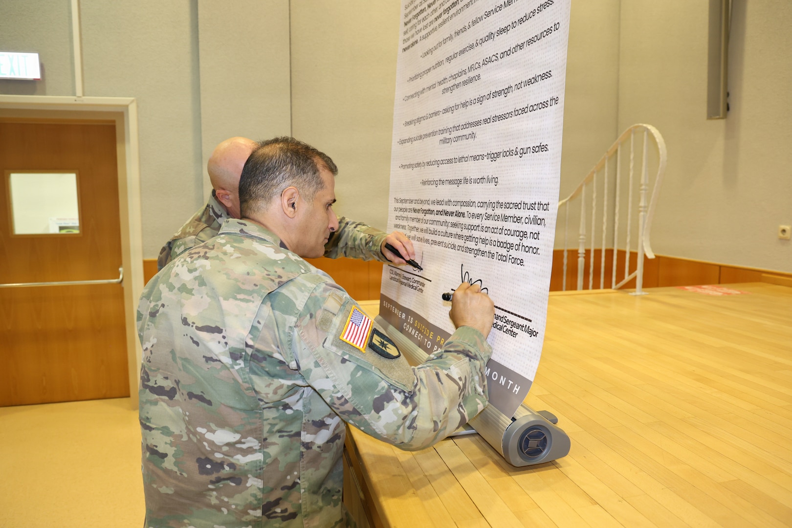 LANDSTUHL, Germany — Col. Warren Stewart, commander of Landstuhl Regional Medical Center, and Command Sgt. Maj. Jorge Oquendo, LRMC senior enlisted leader, sign the Commitment to Suicide Prevention Pledge during the annual Suicide Prevention and Awareness month luncheon Sept .1 at the Heaton Auditorium. The observance included a video featuring messages from LRMC leaders about the importance of suicide prevention and awareness, followed by a fireside chat with behavioral health professionals.