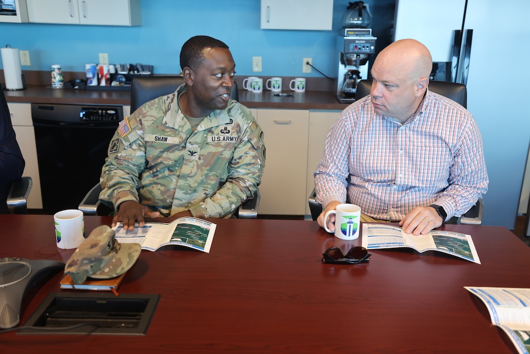 Two men sitting at a table talking.
