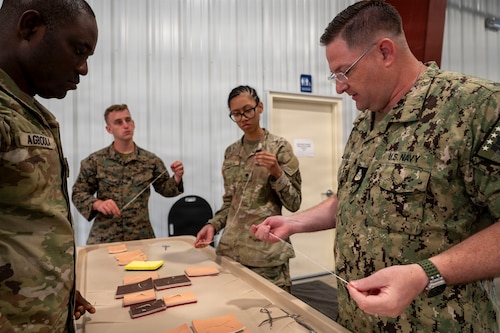 U.S. Navy Senior Chief Petty Officer Justin Williams, a Navy Casualty mortician, explains the qualities of waxed thread for suturing to Exercise Northern Strike 26-2 participants during, at Grayling Army Airfield, Michigan, Aug. 9, 2026.