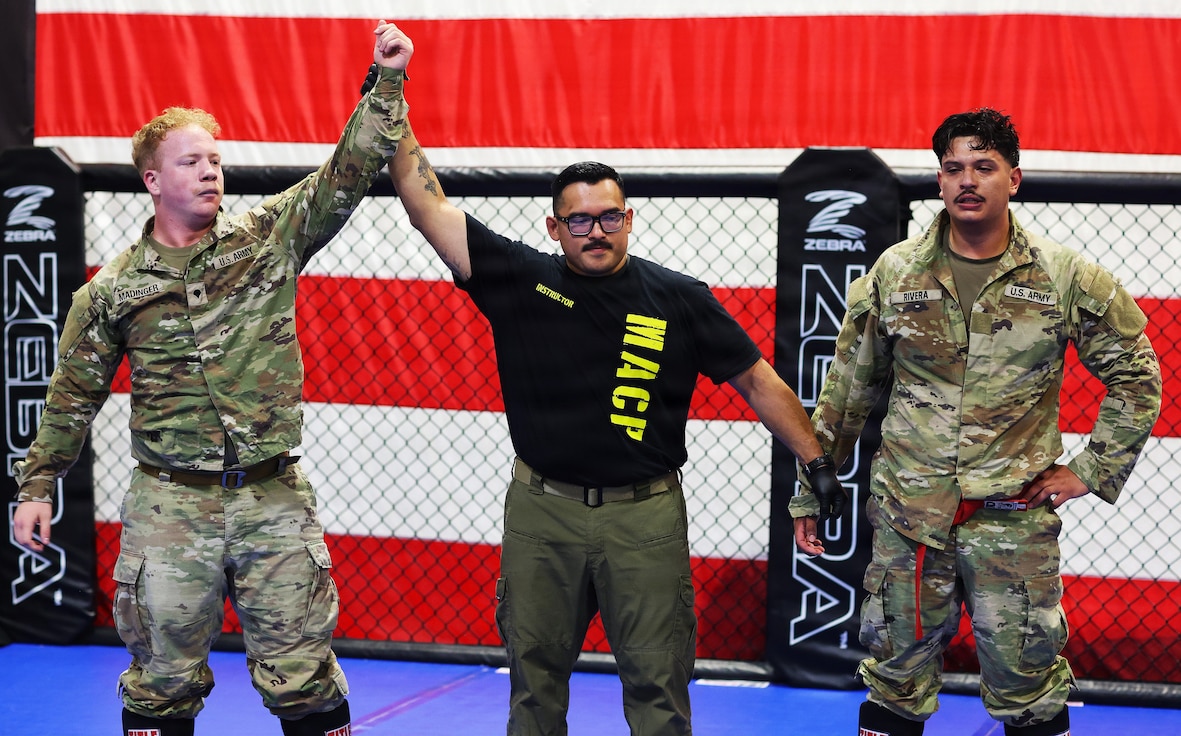 Spc. Bryan Madinger (blue belt) of Marion raises his hand in victory.