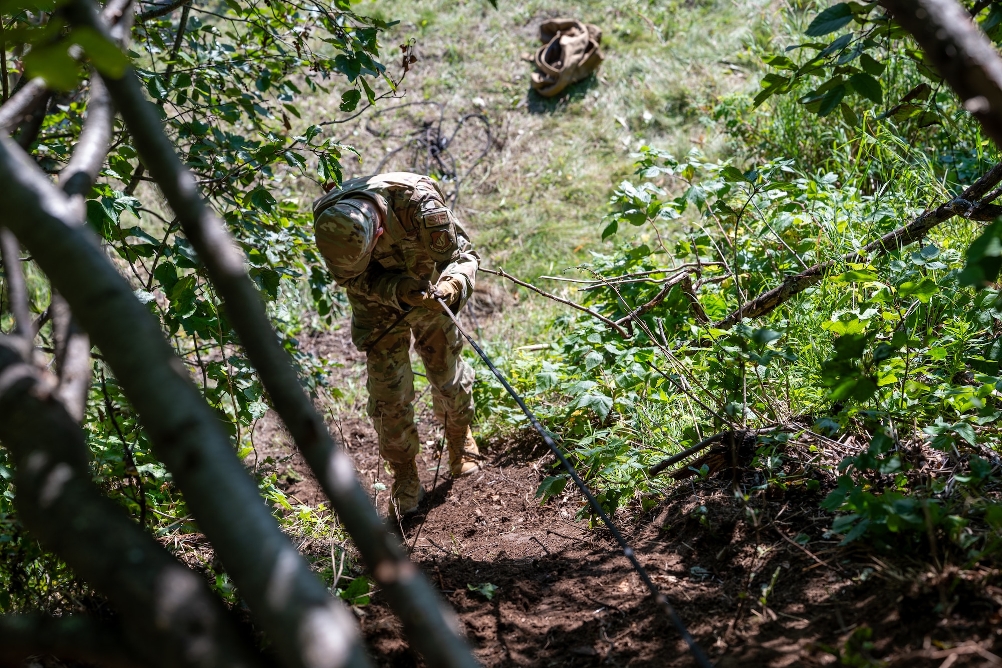 U.S. Air Force Airman Levi Ruyle, a 673d Security Forces Squadron defender, descends a hill using rope-assisted techniques during Alaska Defense Sustainment Training at Joint Base Elmendorf-Richardson, Alaska, Aug. 31, 2026.