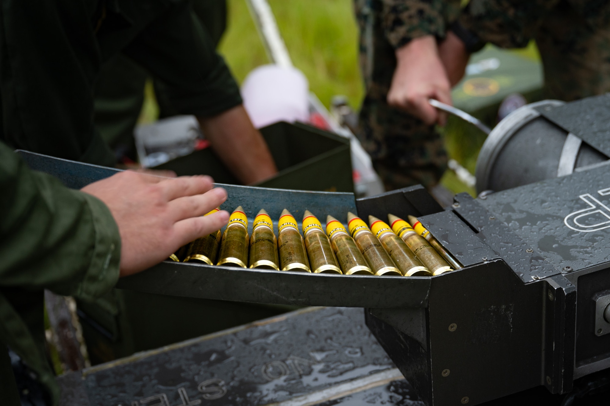 U.S. Marines assigned to Marine Light Attack Helicopter Squadron (HMLA) 773 and Marine Aviation Logistics Squadron (MALS) 49 load 20 mm semi-armor piercing high explosive incendiary rounds into a linkless ammunition loading system at Joint Base McGuire-Dix-Lakehurst, N.J., Aug. 27, 2026. Marines participated in a forward arming and refueling point exercise to maintain readiness and efficiency. (U.S. Air Force photo by Airman 1st Class Haeleigh Bayle)