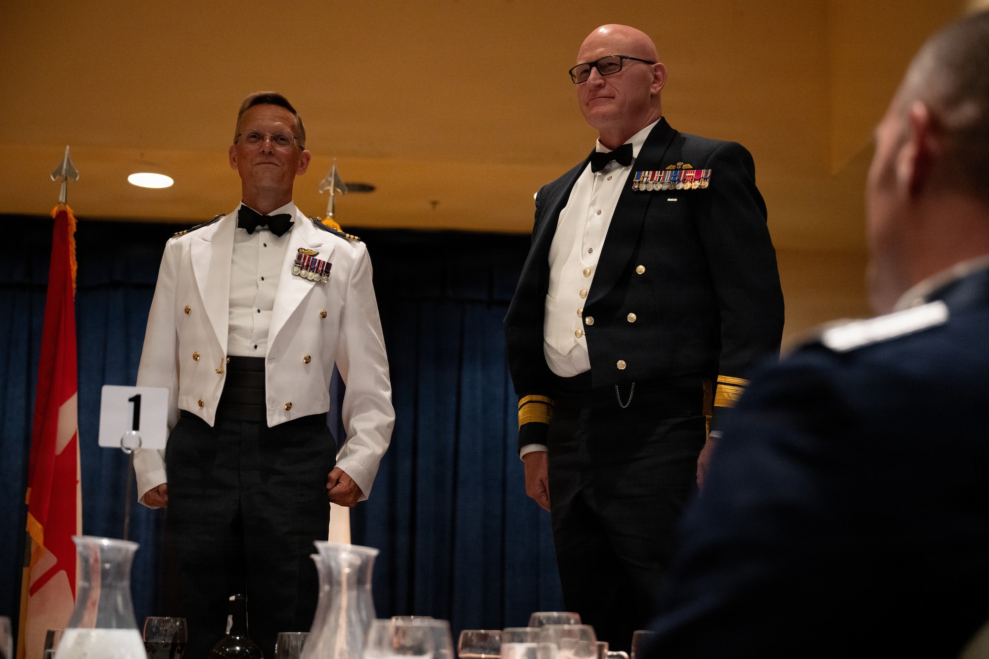 Two servicemembers stand on chairs.