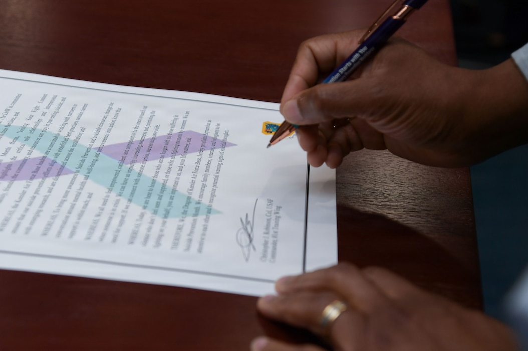 A person is signing a proclamation poster.
