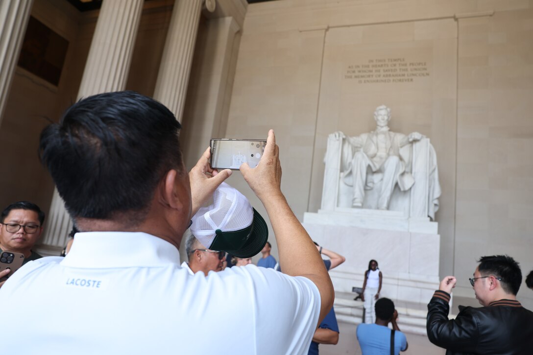 A member of the Lao delegation takes a photo of the Lincoln Memorial