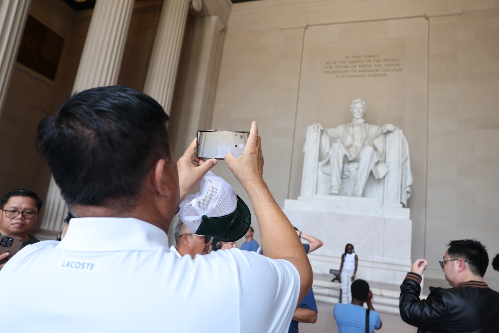 A member of the Lao delegation takes a photo of the Lincoln Memorial
