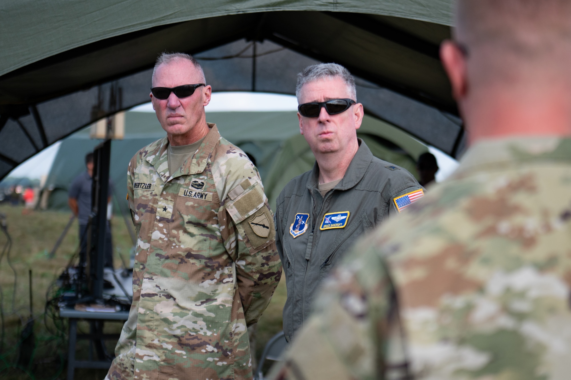 U.S. Army Brig. Gen. Brian F. Wertzler, left, assistant adjutant general for Army, and U.S. Air Force Brig. Gen. Bruce Bancroft, assistant adjutant general for Air, both assigned to Joint Force Headquarters—Kentucky, talk with leadership from the Kentucky Air National Guard’s 123rd Contingency Response Group at Volk Field Combat Readiness Training Center, Wis., Aug. 24, 2026, during exercise Patriot 26. The Air National Guard-hosted exercise brings together approximately 1,000 Airmen and Soldiers from National Guard units across 35 states, along with federal, state and local agencies, to enhance domestic response readiness and interagency coordination during large-scale emergencies. (U.S. Air National Guard photo by Senior Airman Angelee Barnett)