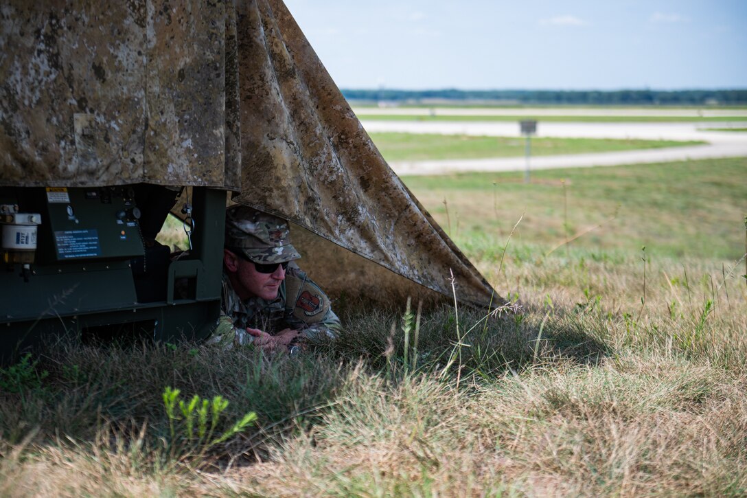 U.S. Air Force Col. Aaron Zamora, commander of the Kentucky Air National Guard’s 123rd Contingency Response Group, seeks cover during a simulated attack at Volk Field Combat Readiness Training Center, Wis., Aug. 25, 2026, during exercise Patriot 26. The Air National Guard-hosted exercise brings together approximately 1,000 Airmen and Soldiers from National Guard units across 35 states, along with federal, state and local agencies, to enhance domestic response readiness and interagency coordination during large-scale emergencies. (U.S. Air National Guard photo by Senior Airman Angelee Barnett)