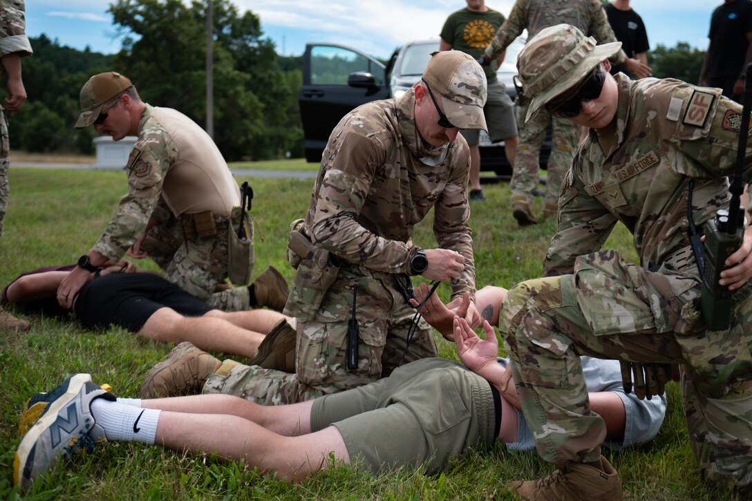 U.S. Air Force Staff Sgt. Tyler McCauley, center, and Airman 1st Class Halena Grace Lozano, right, Security Forces specialists assigned to the Kentucky Air National Guard’s 123rd Contingency Response Group, detain simulated trespassers at Volk Field Combat Readiness Training Center, Wis., Aug. 24, 2026, during exercise Patriot 26. The Air National Guard-hosted exercise brings together approximately 1,000 Airmen and Soldiers from National Guard units across 35 states, along with federal, state and local agencies, to enhance domestic response readiness and interagency coordination during large-scale emergencies. (U.S. Air National Guard photo by Senior Airman Angelee Barnett)