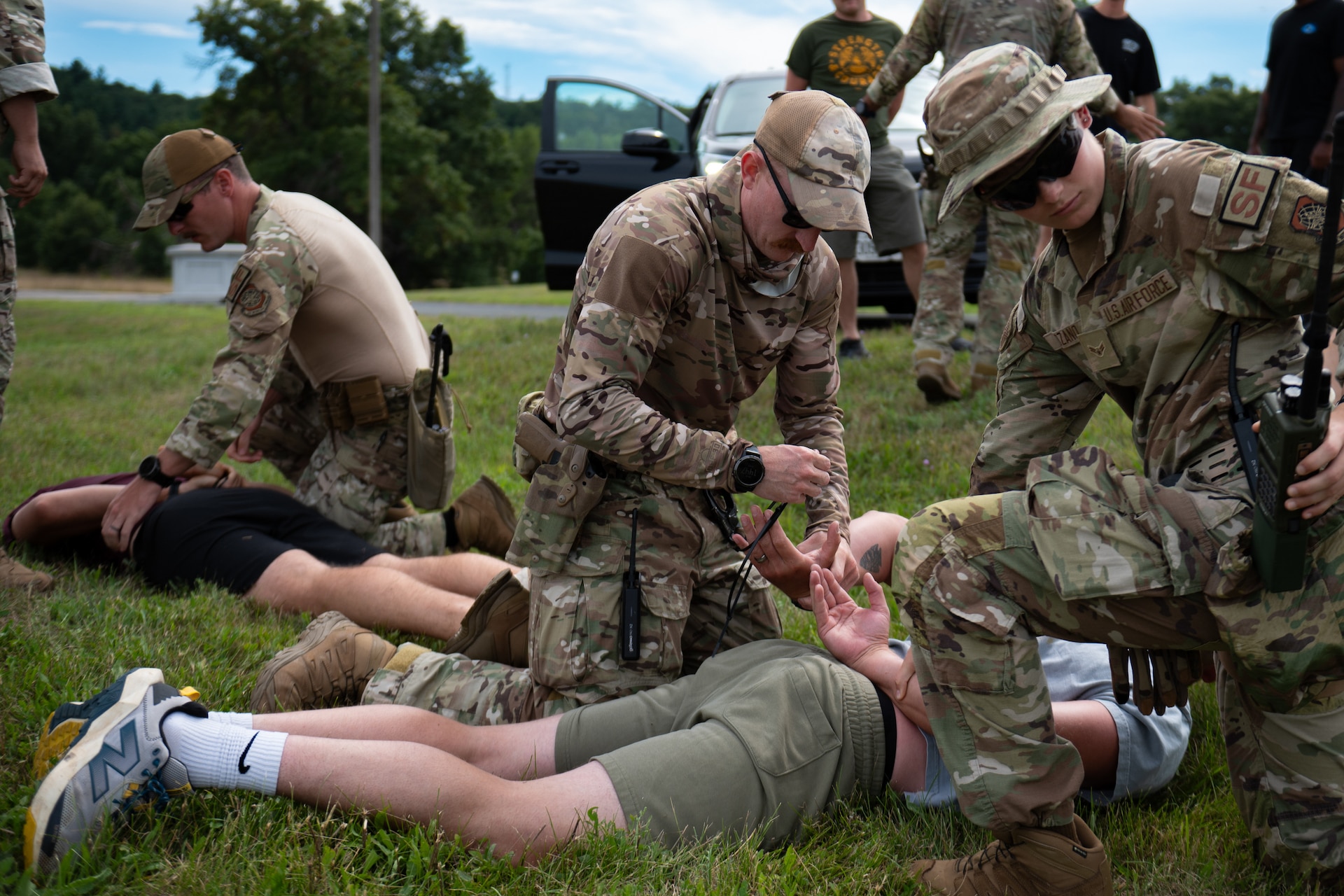 U.S. Air Force Staff Sgt. Tyler McCauley, center, and Airman 1st Class Halena Grace Lozano, right, Security Forces specialists assigned to the Kentucky Air National Guard’s 123rd Contingency Response Group, detain simulated trespassers at Volk Field Combat Readiness Training Center, Wis., Aug. 24, 2026, during exercise Patriot 26. The Air National Guard-hosted exercise brings together approximately 1,000 Airmen and Soldiers from National Guard units across 35 states, along with federal, state and local agencies, to enhance domestic response readiness and interagency coordination during large-scale emergencies. (U.S. Air National Guard photo by Senior Airman Angelee Barnett)