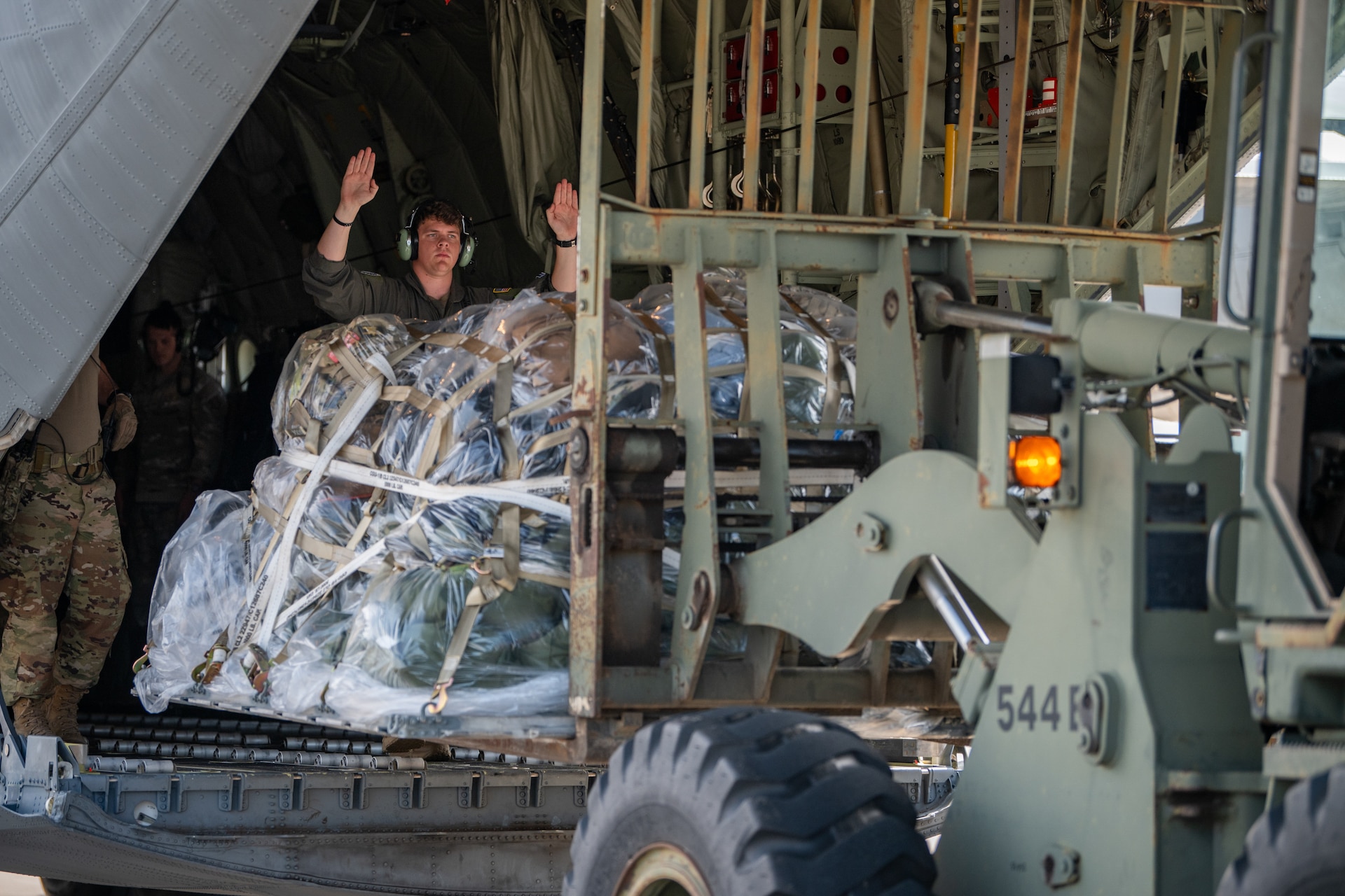U.S. Air Force Airman 1st Class Kyle Brentzel, a loadmaster with the Kentucky Air National Guard’s 123rd Airlift Wing, guides a forklift unloading cargo at Volk Field Combat Readiness Training Center, Wis., Aug. 21, 2026, during Exercise Patriot 26. The Air National Guard-hosted exercise brings together approximately 1,000 Airmen and Soldiers from National Guard units across 35 states, along with federal, state and local agencies, to enhance domestic response readiness and interagency coordination during large-scale emergencies. (U.S. Air National Guard photo by Senior Airman Angelee Barnett)