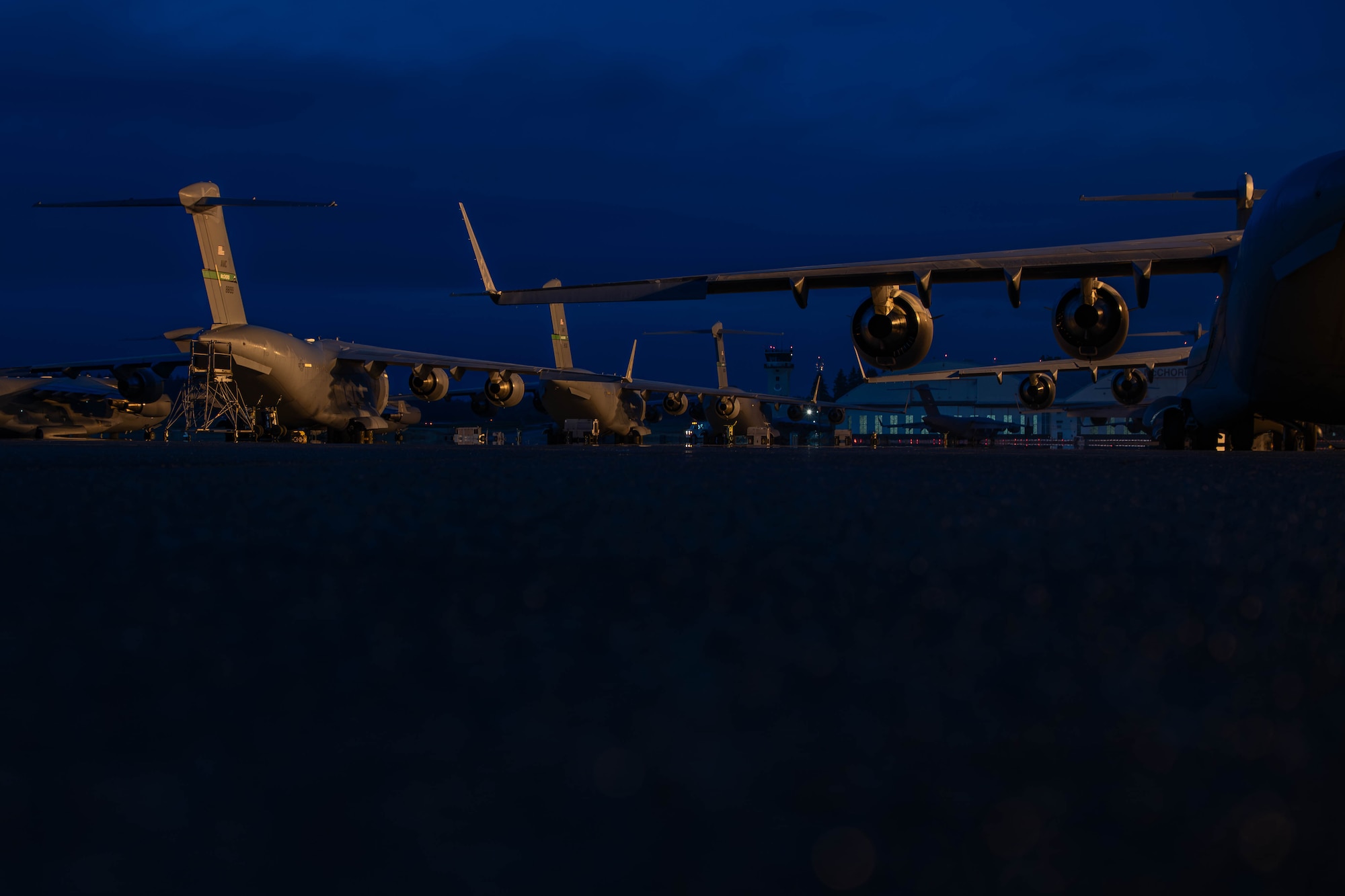 Multiple aircraft sit on a flightline.