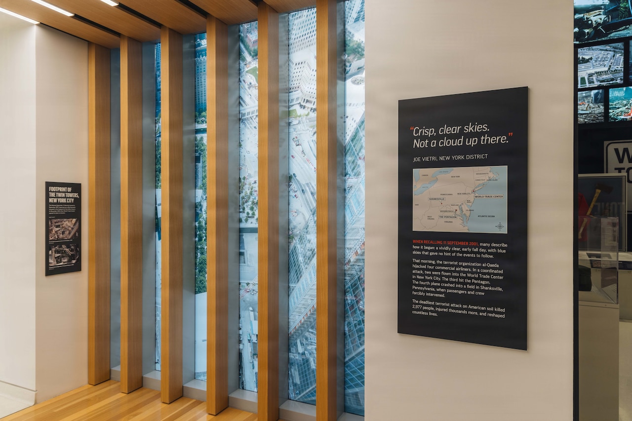 Boards with maps and words as well as photos of damaged sites after 9/11 are on the walls of a museum.