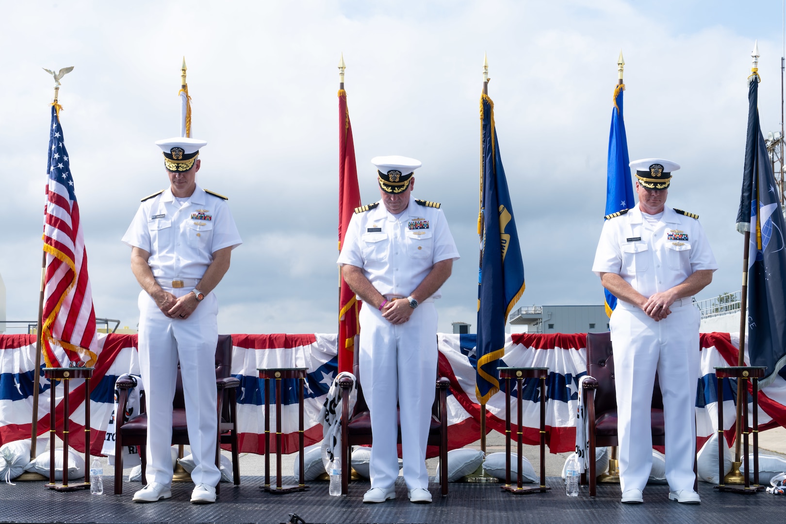 From left to right, U.S. Navy Rear Adm. Peter D. Small, the acting commander for Naval Sea Systems Command, Capt. Joseph J. Oravec, the outgoing commanding officer for Naval Surface Warfare Center Dahlgren Division and Capt. Jason A. Flanagan, the incoming commanding officer, bow their heads during a change of command ceremony at NSWCDD, Dahlgren, Virginia, Sept. 3, 2026. The change of command ceremony is a time-honored tradition which formally signifies the transfer of command and entails total accountability, authority and responsibility from one individual to another. (NSWCDD photo by Jackson Rush)